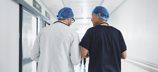 Image showing Doctor, nurse and talk while walk in hospital with advice, consult or communication with medical team. People, discuss or coaching for patient care, treatment and wellness after surgery with joke