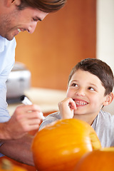 Image showing Halloween, pumpkin and father with kid in the kitchen for holiday celebration at home. Creative, smile and happy dad with boy child bonding and carving vegetable for decoration or tradition at house.