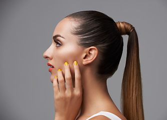 Image showing Manicure, face and profile of woman in makeup, beauty and cosmetics with nails and hair care on grey background. Hand, yellow nail polish and lipstick with skin, glamour and shiny ponytail in studio