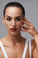 Image showing Face, makeup and woman for beauty with manicure, nail polish and skin with cosmetics isolated on grey background. Red lipstick, color nails and model in portrait with confidence in studio and glamour