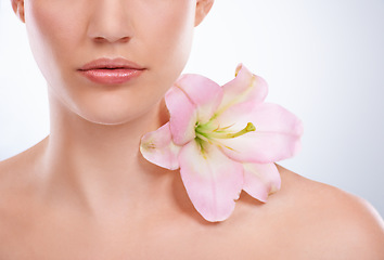 Image showing Closeup, woman and skincare with flowers, beauty and wellness on a white studio background. Half, person and model with natural cosmetics and grooming with treatment, shine and glow with dermatology