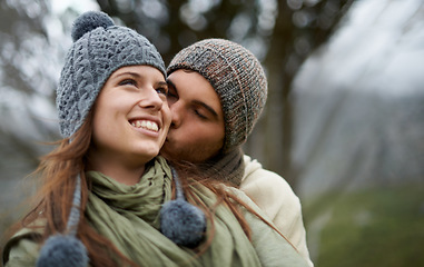 Image showing Couple, kiss and happy outdoor with travel for bonding, love and relationship with winter or holiday. Man, woman and face with embrace or smile on vacation, trip and carefree with romance and care