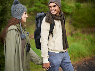 Image showing Forest, hiking and happy couple for holding hands, mountain and travel with backpack, nature and bonding. Outdoor, adventure and trekking in path, woods and winter for travelling and explore
