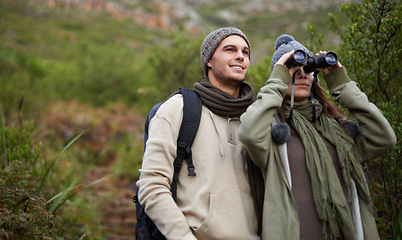 Image showing Couple, travel in nature and binoculars for hiking, adventure and journey or explore together in eco friendly mountains. Happy man and woman trekking with outdoor search, vision or birdwatching lens