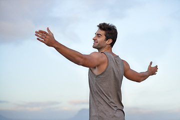 Image showing Sky, happy and excited with man, vacation and journey with wellness and freedom with adventure. Person, outdoor and guy with arms raised, peace and happiness with holiday and adventure with smile