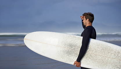 Image showing Looking, surfing and man with surfboard at beach for, waves on summer vacation, weekend and holiday by sea. Travel, nature and person by ocean for water sports, adventure and hobby in Australia