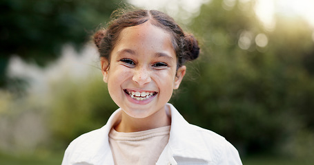 Image showing Child, face and girl laughing outdoor in a garden, park or green environment for fun and happiness. Portrait of a young female latino kid with a positive mindset, cute smile and nature to relax