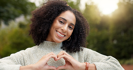 Image showing Face, smile and woman with heart hands, outdoor and support with emoji, kindness and wellness. Portrait, female person or happy girl with symbol for love, self care or peace with trust, park and care
