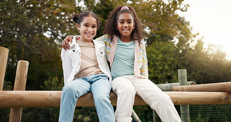 Image showing Friends, happy and children hug in park on jungle gym for bonding, childhood and having fun on playground. Friendship, outdoors and portrait of young girls embrace for playing, freedom and adventure