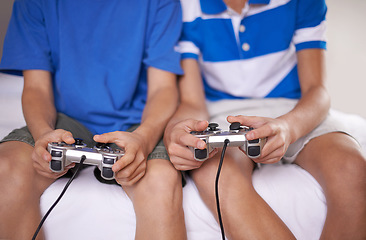 Image showing Video game, hands and closeup of children with controllers on bed for entertainment together. Gamers, console and zoom of boy kid friends playing online for fun or hobby sitting in bedroom of home.