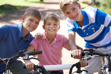 Image showing Brothers, bicycle and portrait for together in park, playing and excited for fun outdoor on vacation. Young children, face and bike riding for skill development, love and bonding in summer on holiday