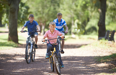 Image showing Nature, happy and portrait of children on bicycle riding in outdoor field, park or forest for exercise. Fun, cycling and confident young boy kids on a bike for cardio, hobby or training in a garden.