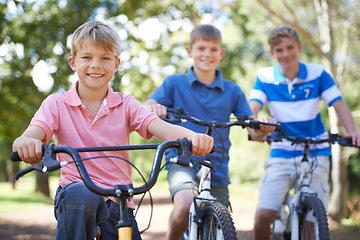 Image showing Nature, smile and portrait of kids on bicycles riding in outdoor field, park or forest for exercise. Happy, cycling and confident young boy children on bikes for cardio, hobby or training in a garden