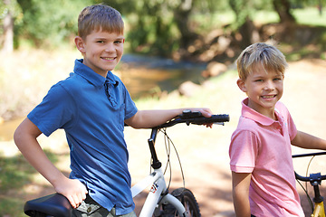 Image showing Nature, bicycles and portrait of boy children riding in outdoor field, park or forest for exercise. Happy, cycling and confident young kids on bikes for cardio, hobby or training in a garden.