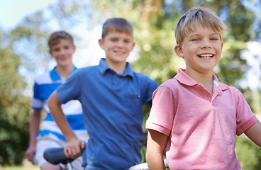 Image showing Nature, smile and kids with bicycle in park learning to ride for exercise in an outdoor forest. Happy, bonding and portrait of young boy children to cycle on bike for hobby in field, woods or garden.