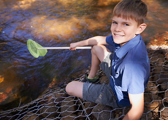 Image showing Child, portrait and fishing net at river in nature for outdoor adventure or youth development, summer or countryside. Kid, boy and equipment for catch hobby in lake for learning, practice or skill