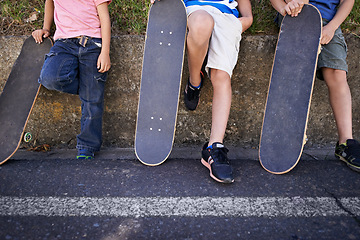 Image showing Kids, friends and skateboard for outdoor relax or exercise sneakers for workout, balance or city street. People, legs and neighbourhood wall rest or fitness on road or transport, practice or urban