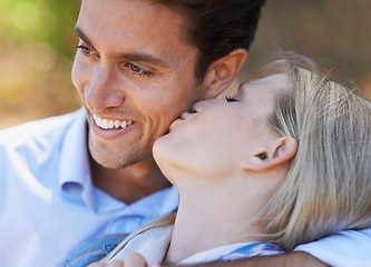 Image showing Happy couple, closeup and kiss in nature for embrace, love or support in relax for outdoor bonding. Young woman kissing man on cheek with smile for affection, comfort or romance in forest together