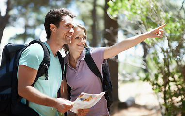 Image showing Couple, hiking in nature and map for direction, documents guide or location information of forest travel or journey. Man and woman trekking with infographics, search woods and pointing to destination