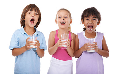 Image showing Happy, children and portrait with milk in glasses for nutrition, health and energy in white background of studio. Calcium, drink and kids smile with dairy, protein and benefits in diet for growth