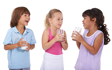 Image showing Happy, children and milk in glasses with nutrition, health and wellness in white background of studio. Calcium, drink and kids smile and laugh with dairy, protein and benefits in diet for energy