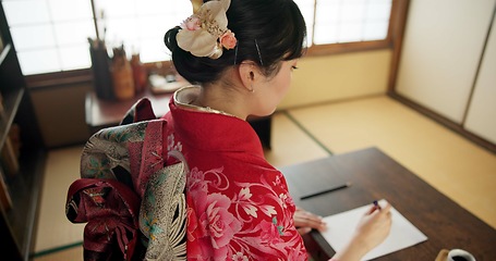 Image showing Traditional, writing and Japanese woman in home with paper, documents and script at desk. Creative, Asian culture and person with paintbrush, ink and tools for calligraphy, font and text in house