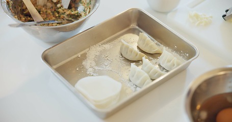 Image showing Japan, dumplings and food on table for dinner, kitchen and traditional meal in restaurant or cafe. Culture, gyozo and asian cuisine for nutrition, healthy diet and lunch with preparation or pastry