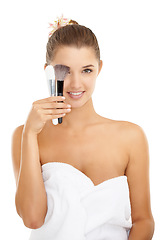 Image showing Cosmetics, studio portrait and woman with brush for foundation application, skincare routine or facial treatment. Makeup tools, beauty salon and dermatology model with towel on white background