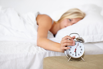 Image showing Alarm, clock and woman wake up in morning on bed in home with fatigue and rest. Press, snooze and girl frustrated with time and tired start to day in bedroom and routine in apartment with timer