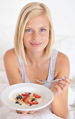Image showing Breakfast, portrait and woman in a bed with muesli, meal or berries for balance, wellness or gut health at home. Fruit, eating or female person face in bedroom for diet, nutrition or superfoods snack