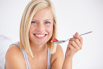 Image showing Portrait, happy woman and eating fruit salad, healthy diet or nutrition in home bedroom. Face smile, spoon or person with strawberry, hungry for breakfast or organic food for wellness in the morning