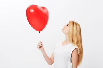 Image showing Studio, heart and balloon with a profile of woman on valentines day isolated on white background. Love, red shape and female person holding a gift or present with romance, emotion or passion for fun
