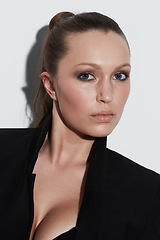 Image showing Portrait, style and beauty of serious woman in studio isolated on a white background. Face, makeup and young model or person in cosmetics, fashion blazer and trendy clothes on a backdrop in Spain