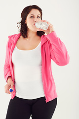 Image showing Woman, portrait and drinking water in fitness for hydration after workout or exercise on a white studio background. Thirsty female person with mineral drink in natural sustainability on break or rest