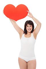 Image showing Portrait, heart and happy plus size woman in studio isolated on a white background. Love, sign or symbol of model in underwear with healthy body for care, kindness emoji and romance on valentines day