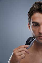 Image showing Man, electric shaver and grooming with closeup studio portrait, space and mockup by grey background. Person, model and shaving beard with hygiene, facial hair removal or product for cosmetic change