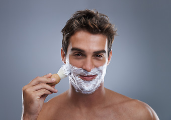 Image showing Man, portrait and shaving cream with brush studio application for healthy skin, hygiene or confidence. Male person, face and beard or fresh hair removal as maintenance care, grey background or mockup