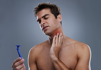 Image showing Man, shaving and beard or razor pain for hair removal or red rash, inflammation or grey background. Male person, tool and cleaning in studio or accident for wellness maintenance, burn or mockup space