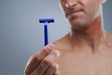 Image showing Grooming, man and razor with routine, closeup and cleaning on a grey studio background. Person, hand and model with tool, cosmetics and treatment with dermatology and equipment with hair removal