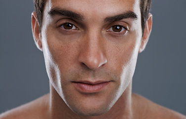 Image showing Portrait, dermatology and man with cosmetics, wellness and confident guy on grey studio background. Face, person and model with beauty or grooming with routine or aesthetic with skincare and shine