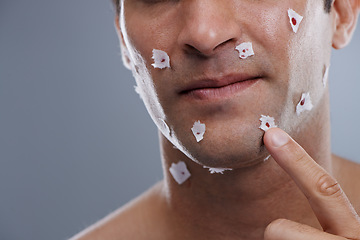 Image showing Man, cuts and skincare with close shave, grooming and morning routine on grey studio background. Person, face and model with paper and bleeding with hair removal and irritation with hygiene or facial