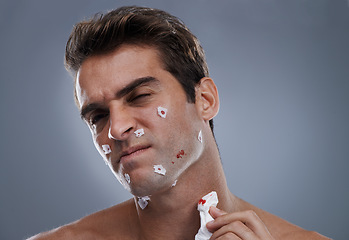 Image showing Man, face and shave cuts for cleaning or hair removal hygiene or injury with blood, tissue or maintenance. Male person, grey background and dermatology with beard or health, studio or mockup space