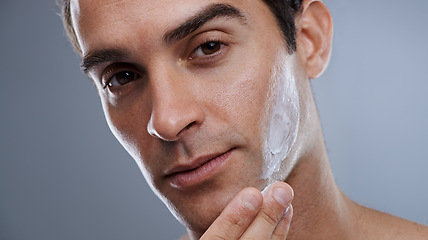 Image showing Portrait, cream and man with dermatology, cosmetics and beauty on a grey studio background. Portrait, person and model with grooming routine or skincare with lotion or moisture after shave with shine