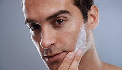 Image showing Portrait, cream and man with skincare, dermatology or wellness on grey studio background. Portrait, person or model with grooming routine or treatment with lotion or moisture with glow or smooth skin