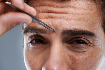 Image showing Man, portrait and tweezers for eyebrows in studio or face grooming, hygiene or grey background. Male person, tools and painful hair removal for healthy morning routine or cosmetics, treatment or care