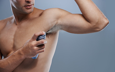 Image showing Smell, wellness and man spray deodorant for hygiene, fragrance or fresh scent after shower on studio background. Perfume, product or model spraying armpit to prevent odor and mockup space with person