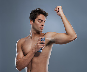 Image showing Man, deodorant and spray for armpit or smell in studio or product application for clean odor, hygiene or grey background. Male person, topless and confidence or health wellness, care or mockup space