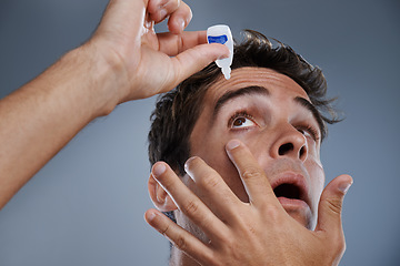 Image showing Man, eye drops and vision for allergies care in studio or healthcare wellness, liquid or grey background. Male person, solution and conjunctivitis dropper for clean pupil or dry, irritation or mockup