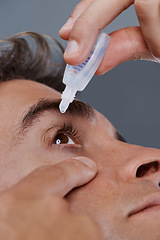 Image showing Man, eye drops and vision for allergies or treatment in studio or healthcare wellness, dropper or grey background. Male person, solution and conjunctivitis for clean pupil or pain, liquid or apply