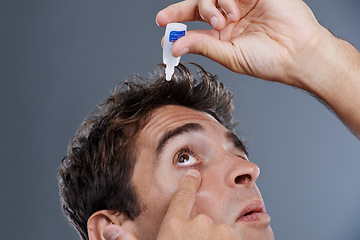 Image showing Man, eye drops and vision for allergies or liquid in studio or healthcare wellness, dropper or grey background. Male person, solution and conjunctivitis for clean pupil or fluid, irritation or mockup